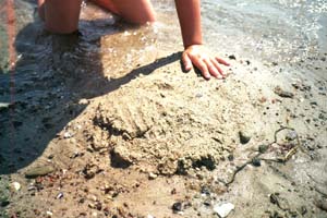 Hand beim spielen mit Sand am Strand